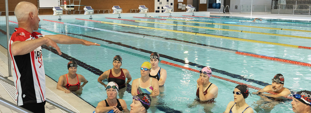 Ironstride's Coach Randy instructing swimmers in a pool